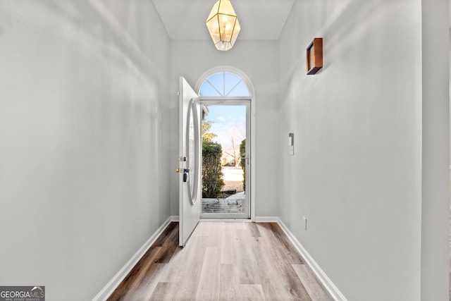 entryway featuring wood-type flooring and an inviting chandelier