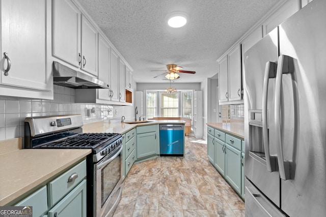 kitchen featuring white cabinets, sink, ceiling fan, decorative backsplash, and appliances with stainless steel finishes