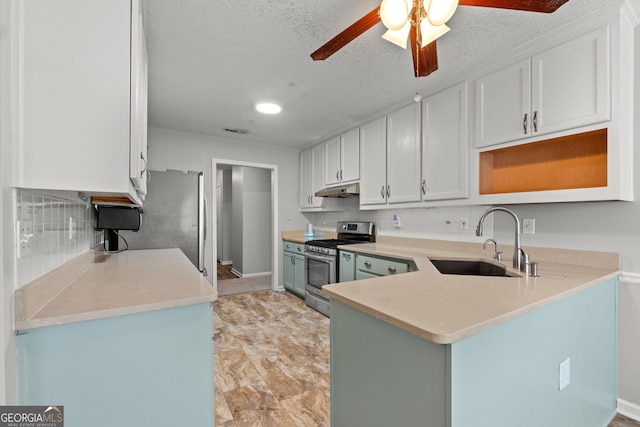 kitchen with a textured ceiling, stainless steel appliances, ceiling fan, sink, and white cabinets