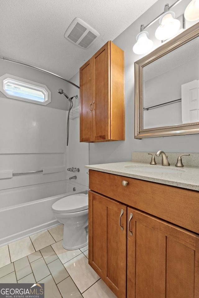 full bathroom with washtub / shower combination, tile patterned floors, a textured ceiling, toilet, and vanity