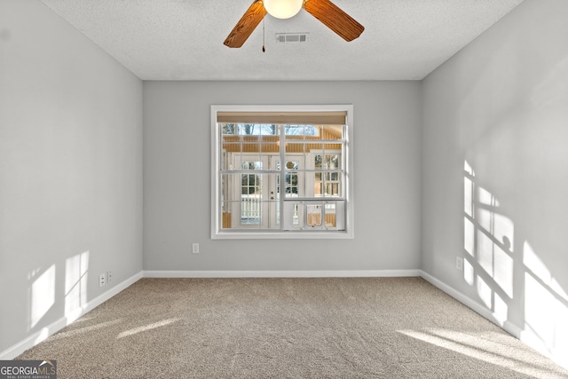 carpeted empty room featuring ceiling fan and a textured ceiling