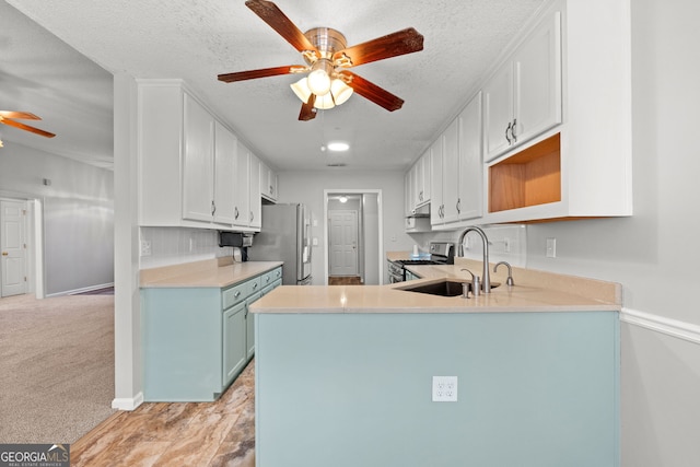 kitchen with white cabinetry, sink, ceiling fan, stainless steel appliances, and light colored carpet