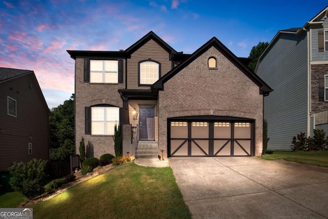 traditional-style house with driveway, a garage, a front lawn, and brick siding