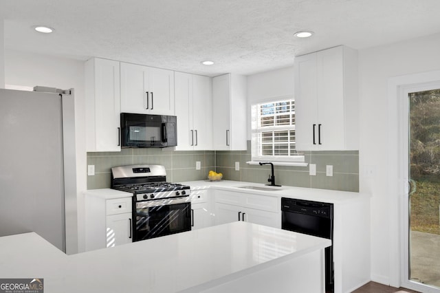 kitchen with sink, white cabinets, and black appliances