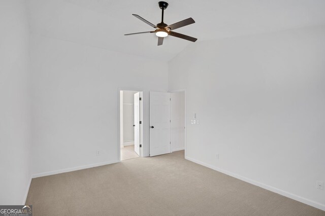 spare room featuring ceiling fan, light carpet, and high vaulted ceiling