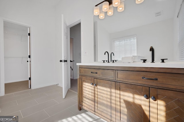 bathroom with tile patterned floors, vanity, and lofted ceiling