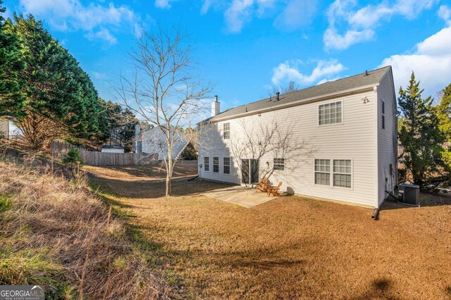 rear view of house with a lawn, a patio area, and central air condition unit