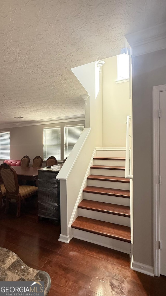 stairway with hardwood / wood-style flooring and a textured ceiling