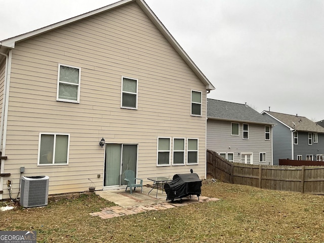 rear view of house featuring a yard, central AC unit, and a patio area