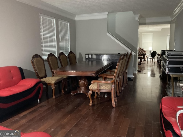 dining space featuring a textured ceiling, ornamental molding, and dark wood-type flooring