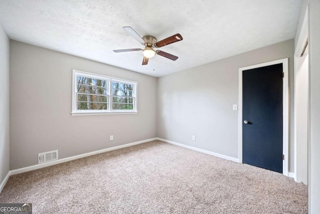 carpeted empty room featuring a textured ceiling and ceiling fan