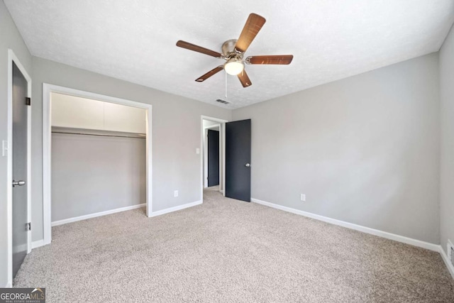 unfurnished bedroom with ceiling fan, a closet, carpet, and a textured ceiling