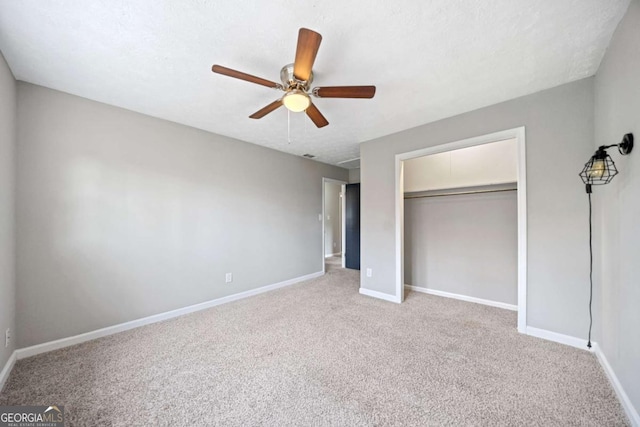 unfurnished bedroom featuring ceiling fan, a closet, and light carpet