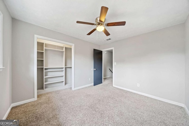 unfurnished bedroom featuring carpet floors, a closet, and ceiling fan