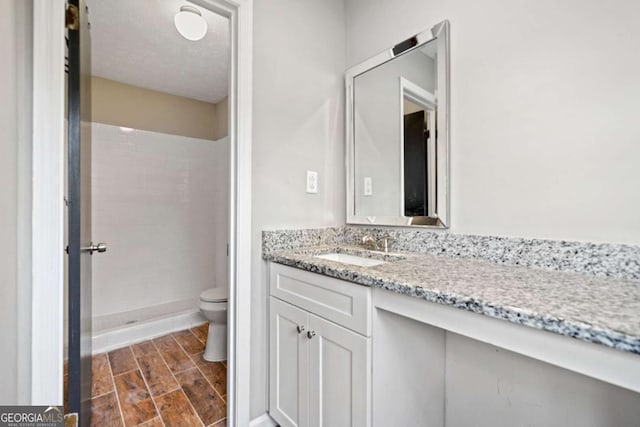 bathroom featuring vanity, toilet, and walk in shower