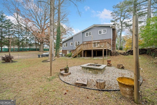 back of house with a yard, a fire pit, and a deck