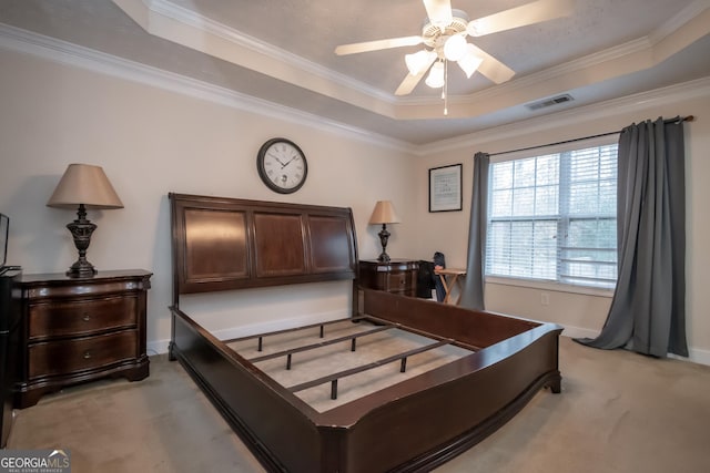 carpeted bedroom featuring a tray ceiling, ceiling fan, and crown molding