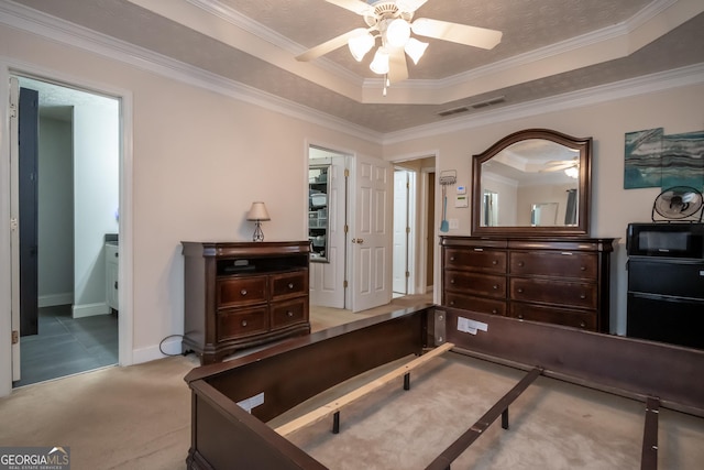 bedroom with ceiling fan, ornamental molding, and a tray ceiling