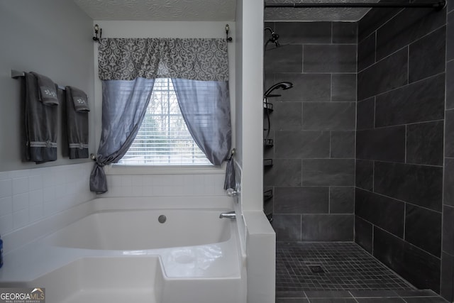 bathroom with independent shower and bath and a textured ceiling