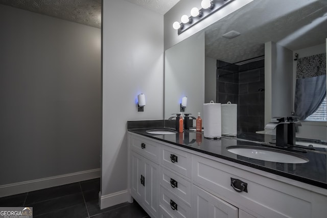 bathroom featuring tile patterned flooring, vanity, a shower, and a textured ceiling