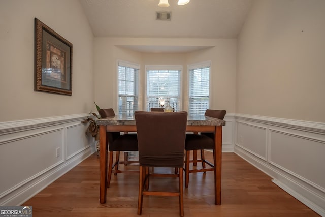 dining space with dark hardwood / wood-style flooring and lofted ceiling