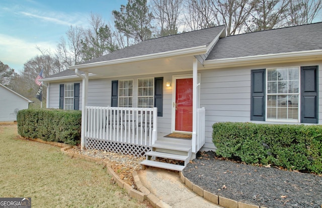 ranch-style home featuring a porch and a front lawn