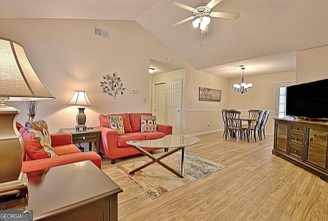 living room featuring ceiling fan with notable chandelier, light hardwood / wood-style floors, and vaulted ceiling