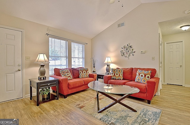 living room with ceiling fan, light hardwood / wood-style flooring, and vaulted ceiling