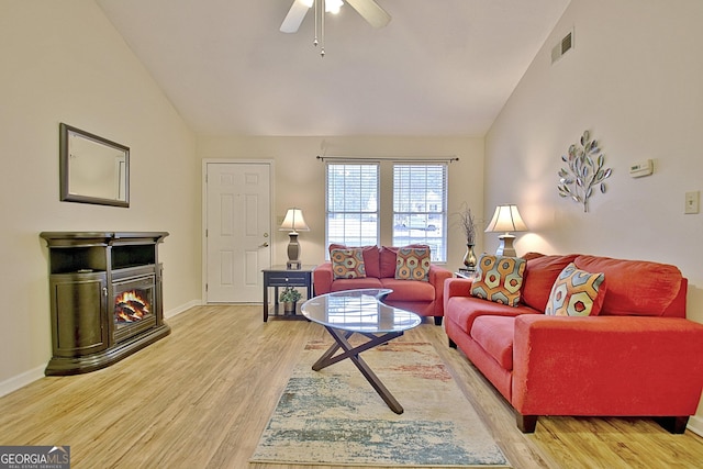 living room featuring ceiling fan, light hardwood / wood-style floors, and lofted ceiling