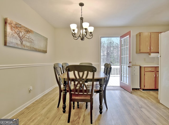 dining space with light wood-type flooring and a chandelier