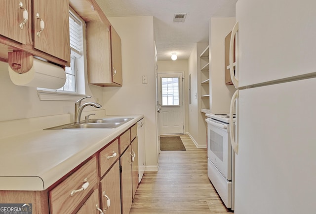 kitchen with a textured ceiling, sink, light hardwood / wood-style floors, and white appliances