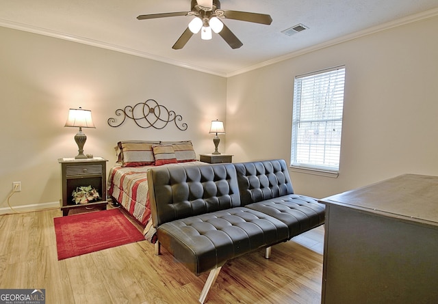 bedroom featuring light hardwood / wood-style floors, ceiling fan, and crown molding