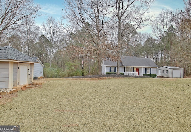 view of front of home with covered porch, a storage unit, and a front yard