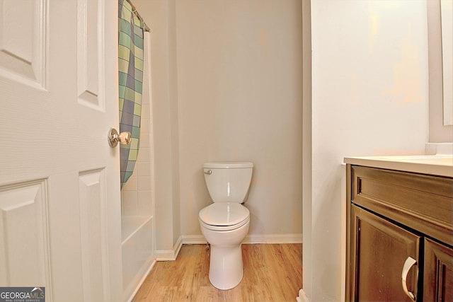 full bathroom with hardwood / wood-style floors, vanity, toilet, and shower / tub combo with curtain