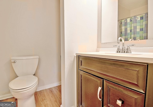 bathroom with hardwood / wood-style floors, vanity, and toilet