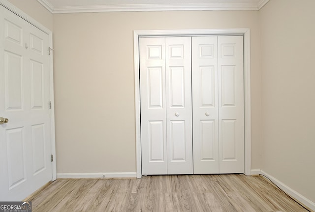 unfurnished bedroom featuring light hardwood / wood-style flooring, a closet, and ornamental molding