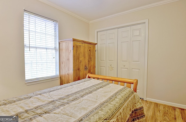 bedroom with hardwood / wood-style floors, ornamental molding, and a closet