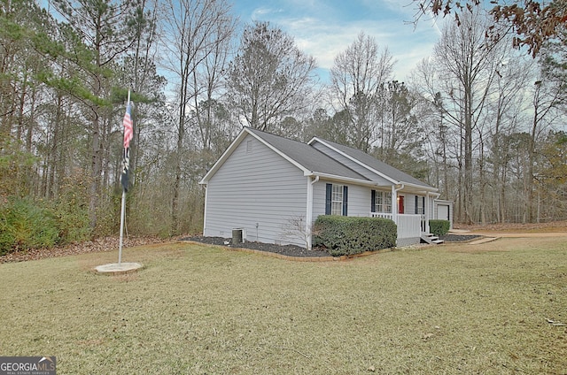 view of side of property featuring a lawn, a porch, and central air condition unit