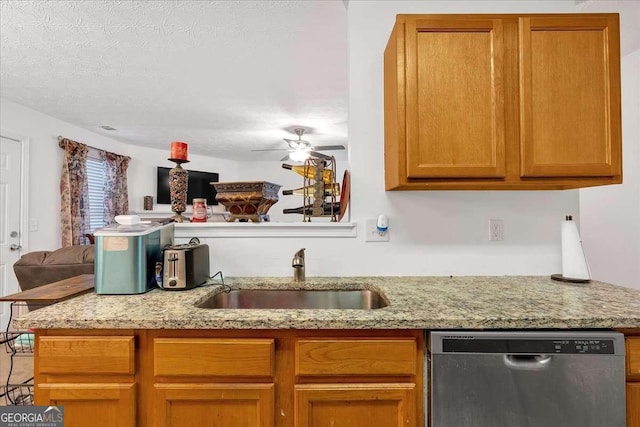 kitchen with light stone countertops, sink, ceiling fan, stainless steel dishwasher, and a textured ceiling