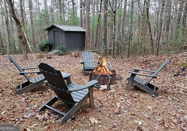 view of yard featuring a shed and a fire pit