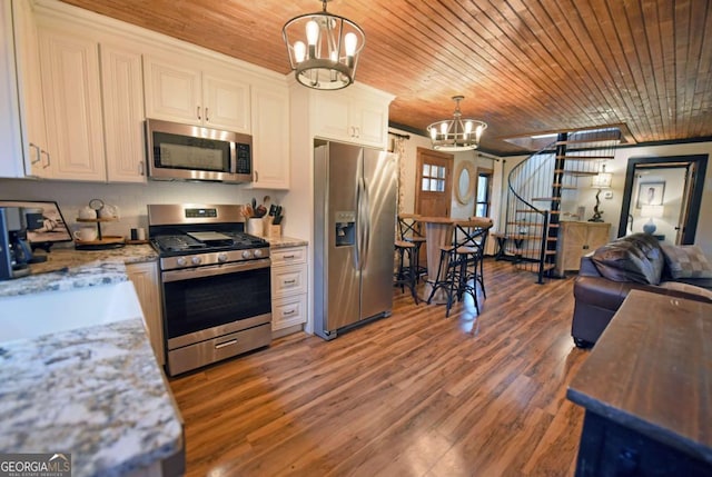 kitchen with white cabinets, wood ceiling, decorative light fixtures, and appliances with stainless steel finishes