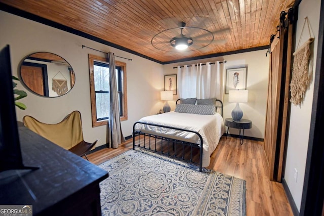 bedroom featuring a barn door, wooden ceiling, light wood-type flooring, and ornamental molding