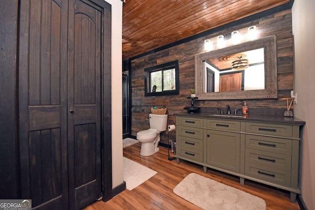 bathroom with wooden ceiling, wood-type flooring, toilet, wooden walls, and vanity