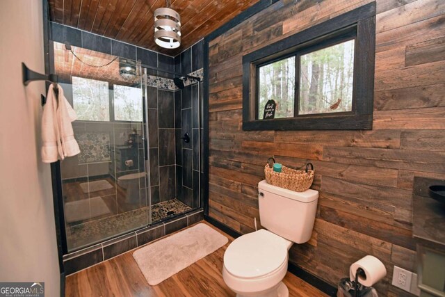 bathroom with wooden ceiling, walk in shower, wood walls, toilet, and hardwood / wood-style flooring