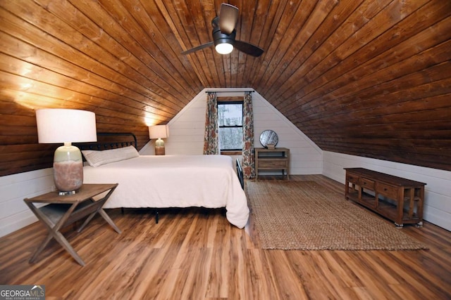 unfurnished bedroom featuring ceiling fan, wood walls, wooden ceiling, and vaulted ceiling