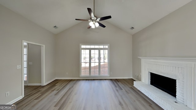 unfurnished living room with high vaulted ceiling, light hardwood / wood-style flooring, a brick fireplace, and ceiling fan