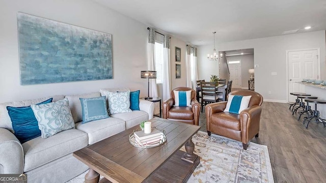 living room with a notable chandelier and light hardwood / wood-style floors