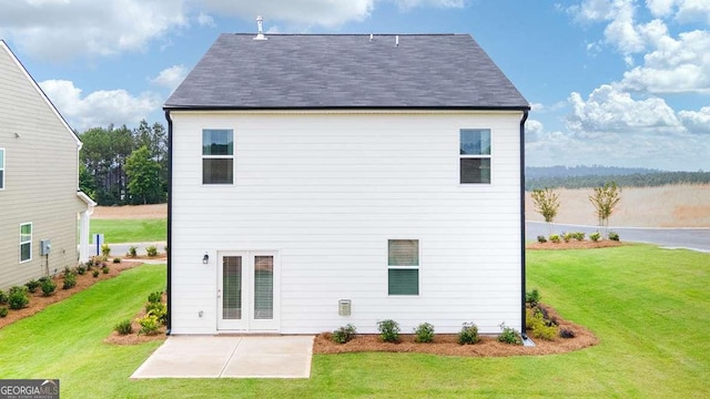 back of house with a yard and a patio