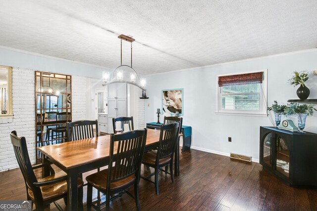 dining room with a textured ceiling, crown molding, and dark wood-type flooring