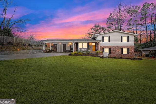 split level home featuring a lawn and covered porch